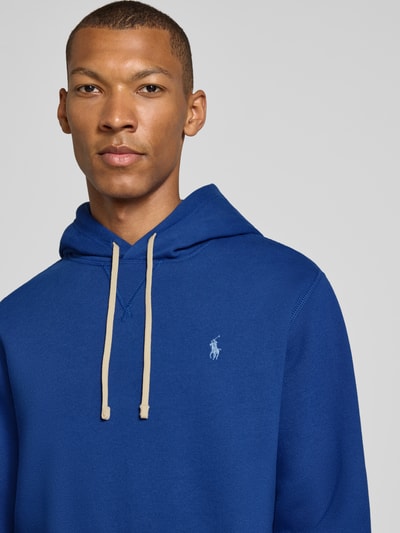 Männermodel trägt Regular Fit Hoodie aus Baumwoll-Mix von Polo Ralph Lauren in Blau mit beigefarbenen Kordeln, Nahaufnahme Oberkörper, Herren Hoodie von Polo Ralph Lauren.
