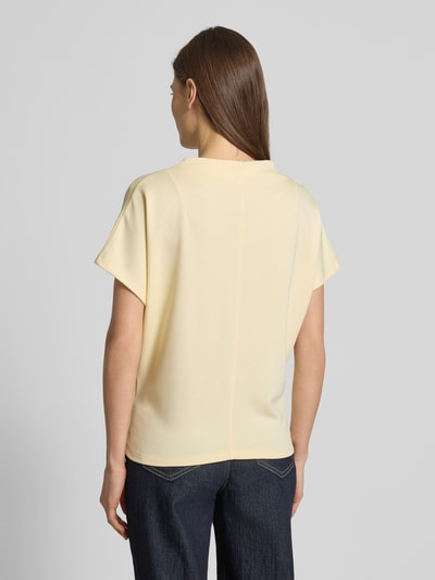 Vrouwenmodel draagt lichtgeel regular fit T-shirt uit viscosemix model 'Kiline' van Someday, opstaande kraag, ruglengte maat 36: 58 cm. Ganzkörperansicht Rückansicht.