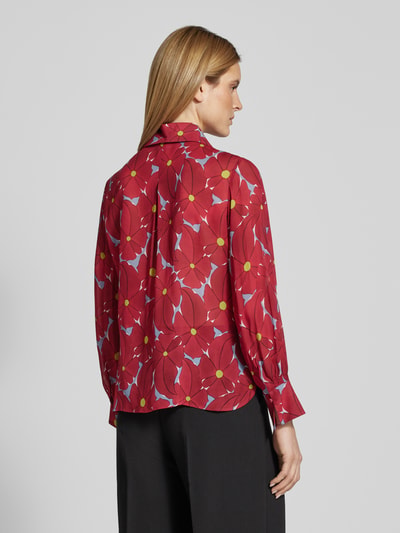 Vrouwenmodel draagt Schluppenbluse aus Viskose mit Schluppenkragen van Luisa Cerano, rood met blauwe bloemen, rechte fit, rugaanzicht.