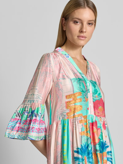 Modelka kobieca nosi Relaxed Fit Minikleid aus reiner Viskose Modell 'Love' od miss goodlife, wzór kwiatowy, półrękaw, V-dekolt, czysta wiskoza, długość tyłu w rozmiarze S: 88 cm, szerokość w rozmiarze S: 50 cm, długość rękawa w rozmiarze S: 47 cm, kolorowe pastelowe barwy, delikatna tekstura, zbliżenie na górną część ciała, ujęcie z przodu.