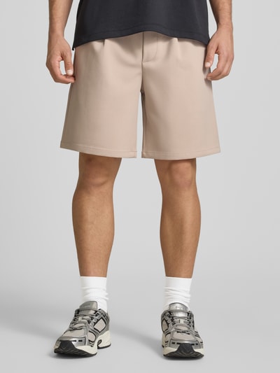 Männermodel trägt Loose Fit Shorts mit elastischem Bund Modell 'WILL' von Only & Sons, unifarben, Bundfalte, Nahaufnahme Oberschenkel