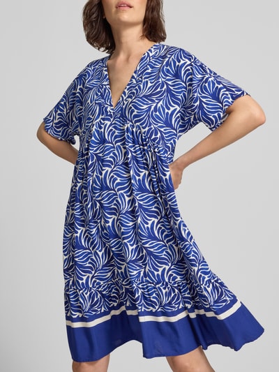Frauenmodel trägt knielanges Kleid aus Viskose Modell 'Me44la' von ZABAIONE, blau-weißes Allover-Muster, V-Ausschnitt, A-Linie, Nahaufnahme Oberkörper.