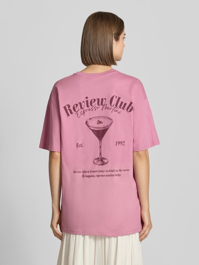 Frauenmodel trägt Oversized Fit T-Shirt aus reiner Baumwolle mit Label-Detail von REVIEW in Rosa mit Print auf der Rückseite, Ganzkörperansicht Rückansicht.