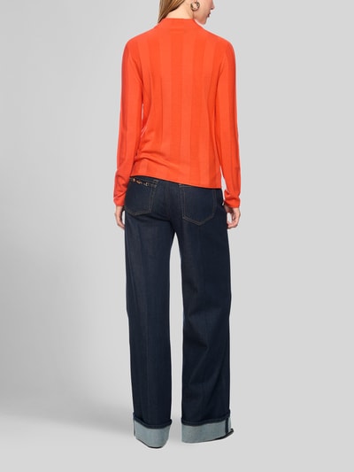 Frauenmodel trägt Strickpullover aus Schurwolle-Mix mit Stehkragen von Marc Cain in Orange, schlichte Struktur, Ganzkörperansicht Rückansicht. Kontext: Damen Strickpullover, Schurwolle-Mix mit Kaschmir-Anteil, Slim Fit, Label-Detail, Rückenlänge 55 cm, Ärmellänge 66 cm.
