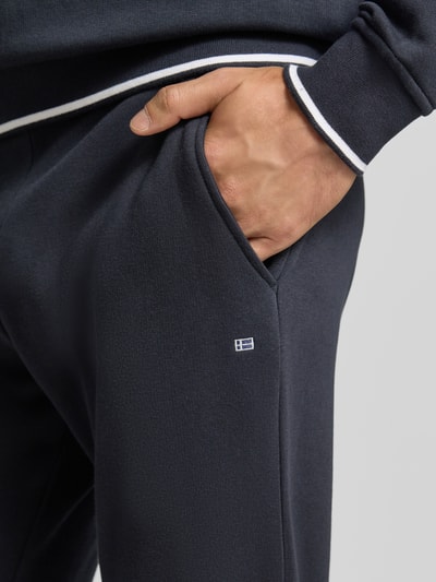 Männermodel trägt Sweatpants mit elastischem Bund und Kordelzug von Christian Berg Men in dunkelblau, Baumwoll-Mix, Nahaufnahme Oberschenkel.