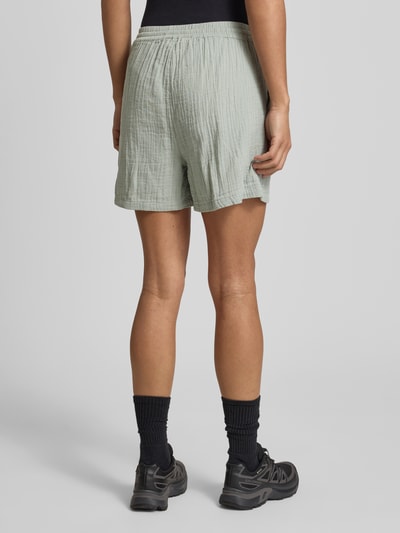 Männermodel trägt Relaxed Fit Shorts aus reiner Baumwolle Modell 'THYRA' von Only, jednolity kolor, materiał crêpe, elastyczny pas, kieszenie boczne, widok całej sylwetki z tyłu.