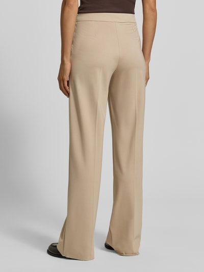 Frauenmodel trägt Hose mit Bügelfalten Modell 'PALACE' von EMME in Beige, glatte Viskose-Stretch-Optik, Regular Fit, Ganzkörperansicht Rückansicht.