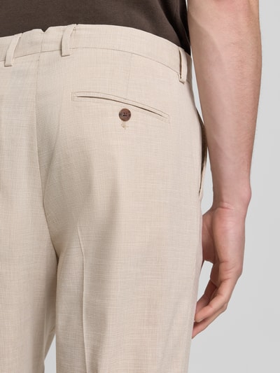 Männermodel trägt Regular Fit Anzughose mit Leinen-Anteil Modell 'STYLE.MAINE' von SELECTED HOMME, Hahnentritt, helle Beige-Töne, Nahaufnahme Rückansicht.