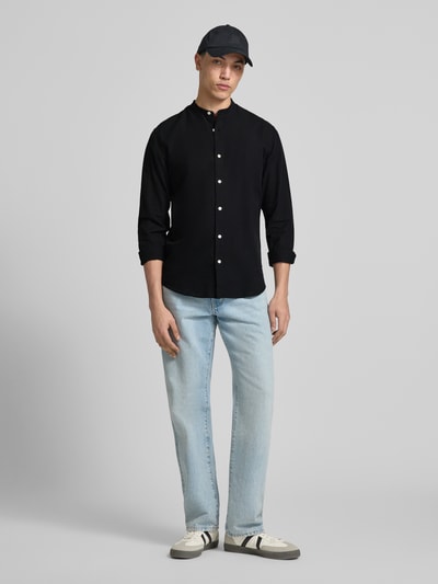 Männermodel trägt Freizeithemd mit Leinen-Anteil Modell 'BREEZE' von Jack & Jones, Baumwoll-Leinen-Mix, Regular-Fit, Stehkragen, Knopfleiste, Ganzkörperansicht von vorne.