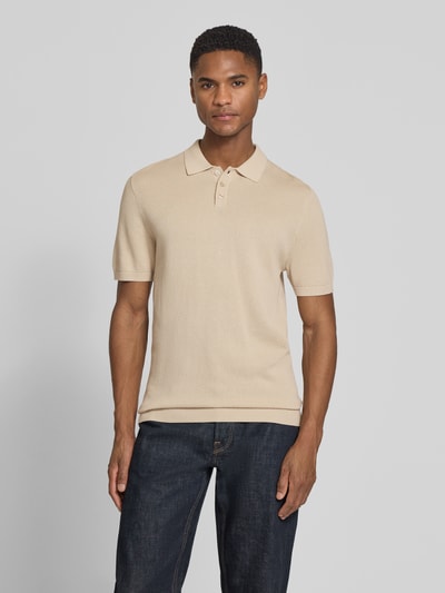 Männermodel trägt Slim Fit Poloshirt mit Strukturmuster Modell 'TRITON' von Drykorn in Beige, Knopfleiste, Ganzkörperansicht von vorne.