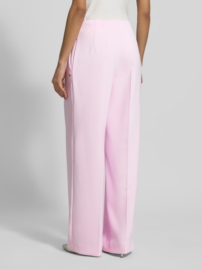 Frauenmodel trägt Wide Fit Stoffhose mit Bügelfalten von Marc Cain in Rosa, Material-Mix mit Stretch-Anteil, High-Waist, Ganzkörperansicht Rückansicht.