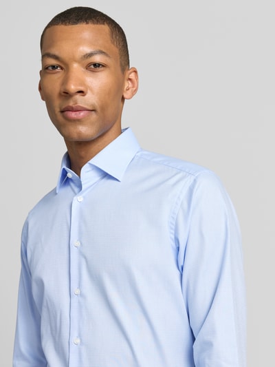 Männermodel trägt hellblaues Regular Fit Business-Hemd mit Kentkragen von Christian Berg Men aus Reine Baumwolle, Nahaufnahme Oberkörper. Rückenlänge bei Größe 39/40: 78 cm, Schulterbreite bei Größe 39/40: 43 cm, Ärmellänge bei Größe 39/40: 65 cm, Knopfleiste, Sportmanschetten, abgerundeter Saum.