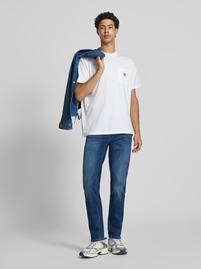 Männermodel trägt Slim Fit Jeans aus Baumwoll-Mix Modell 'Hatch' von Pepe Jeans in Blau, Herren Slim Fit Jeans, Ganzkörperansicht von vorne.