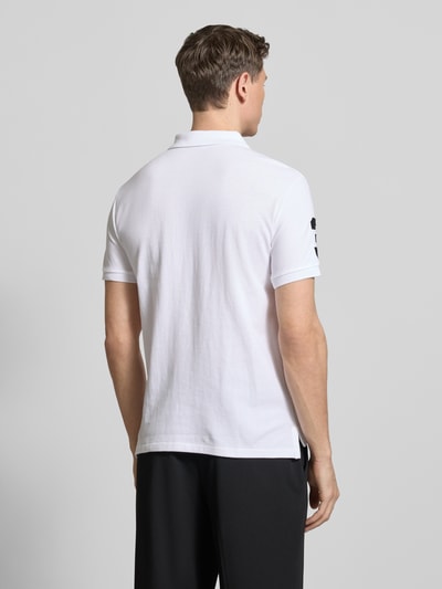 Männermodel trägt Shaped Fit Poloshirt aus reiner Baumwolle von Polo Ralph Lauren, Optik: Unifarben, Piqué-Textur, Ganzkörperansicht Rückansicht.