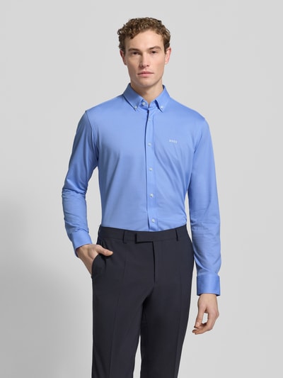 Männermodel trägt Regular Fit Businesshemd aus Pinpoint mit Stretch-Anteil von BOSS in Hellblau, Baumwoll-Mix, Knopfleiste, Button-Down-Kragen, Logo-Schriftzug, Sportmanschetten, pflegeleicht und atmungsaktiv, Ganzkörperansicht von vorne.