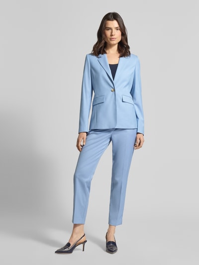 Frauenmodel trägt Slim Fit Blazer mit Pattentaschen von More & More, hellblauer Material-Mix mit Viskose-Anteil, Ganzkörperansicht von vorne.