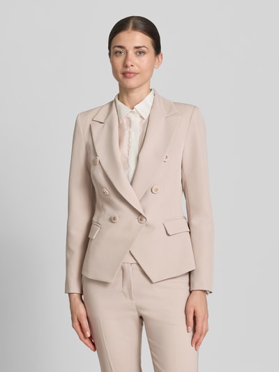Frauenmodel trägt Blazer mit Pattentaschen Modell 'REWI' von Rinascimento in Beige mit Reverskragen, tailliert, glatte Textur, Ganzkörperansicht von vorne.