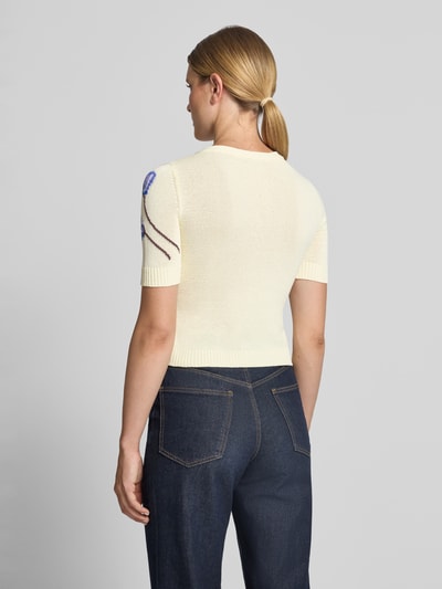 Frauenmodel trägt Slim Fit Sweatjacke aus Baumwoll-Mix Modell 'RANCH' von MAX&Co. in Strickoptik mit floralem Intarsienmuster, helles Creme, gerippte Abschlüsse, Ganzkörperansicht Rückansicht.