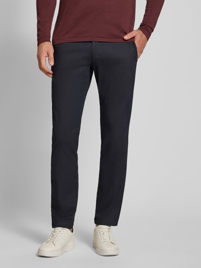 Männermodel trägt Slim Fit Chino aus Baumwoll-Mix von bugatti in Dunkelblau, matt, glatte Oberfläche, Münztasche, Ganzkörperansicht von vorne.