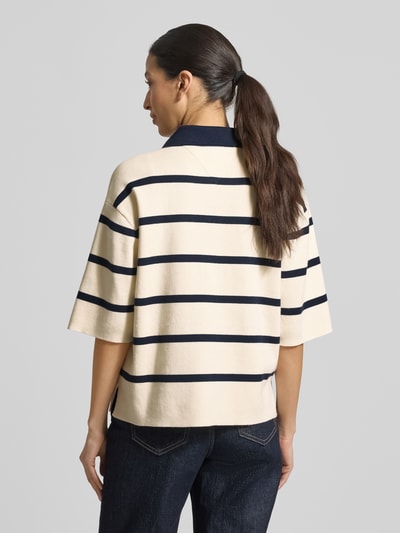 Vrouwenmodel draagt Regular Fit Poloshirt uit katoenmix van Tommy Hilfiger, all-over motief, fijngebreid, logo-stitching, polokraag, lange mouw, mouwboord geribd, rompzoom met split, katoenmixa. Ganzkörperansicht Rückansicht.