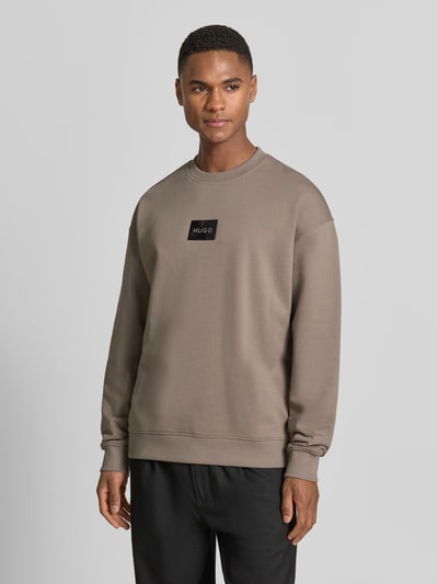 Männermodel trägt Regular Fit Sweatshirt aus reiner Baumwolle Modell 'DAYLO' von HUGO, Optik: Unifarben, Label-Applikation, Ganzkörperansicht von vorne.