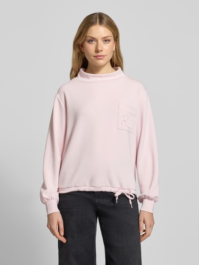 Frauenmodel trägt Sweatshirt mit Stehkragen und Brusttasche von monari, Modal-Mix mit Stretch-Anteil, Regular-Fit, Tunnelzug, hellrosa, Ganzkörperansicht von vorne.