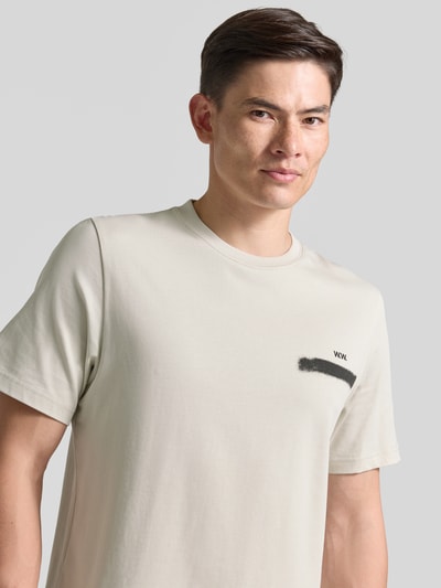 Męskimodel nosi t-shirt z czystej bawełny, okrągły dekolt, nadruk z logo z przodu, model 'Bobby' Wood Wood, krój regular fit, kolor jasny, Nahaufnahme Oberkörper.