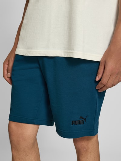 Männermodel trägt Shorts mit Logo und elastischem Bund von PUMA in Blau, Baumwoll-Mix, Regular Fit, Nahaufnahme Oberschenkel, Bund sichtbar.