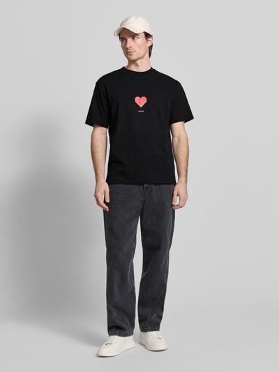 Männermodel trägt Regular Fit T-Shirt aus reiner Baumwolle Modell 'DALENTIN' von HUGO, Optik: unifarben, Motiv-Print, Ganzkörperansicht von vorne