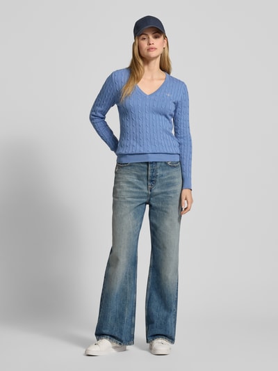 Modelka kobieca nosi niebieski Strickpullover mit Zopfmuster und Label-Stitching od Gant, bawełniany, slim fit, V-neck, pełny przód. Ganzkörperansicht von vorne.