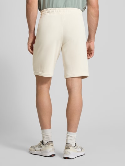 Männermodel trägt Shorts mit Label-Stitching von PUMA PERFORMANCE in Beige, elastischer Bund, Baumwoll-Mix, Ganzkörperansicht Rückansicht.