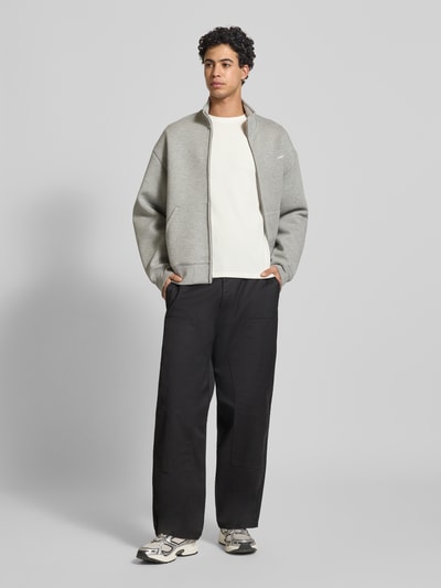 Męski model nosi Sweatshirt mit Stehkragen od Replay z bawełny, krój prosty, stójka, faktura wafla, detal z logo, elastyczne zakończenia rękawów, długość tyłu 63 cm, długość rękawów 67 cm, widok całej sylwetki z przodu