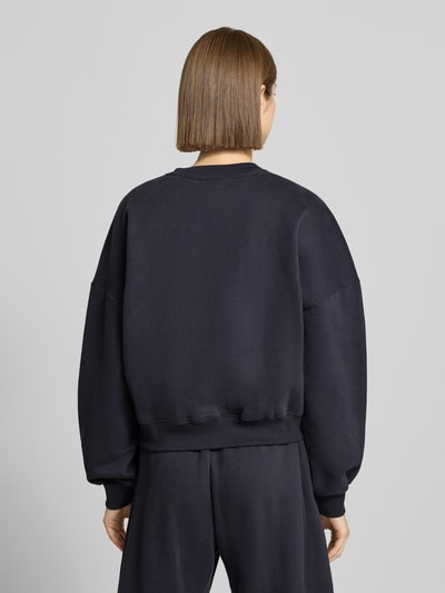 Vrouwenmodel draagt Sweatshirt met Labelprint en ronde hals van Review, katoenmix, relaxed fit, effen donkerblauw. Ganzkörperansicht Rückansicht.