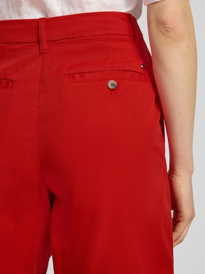 Kobiece model prezentuje Regular Fit Chino-Shorts aus Baumwoll-Lyocell-Mix od Tommy Hilfiger, efekt: jednolity kolor, wyhaftowane logo, zapięcie na guzik i zamek błyskawiczny, wpuszczane kieszenie z przodu, kieszenie z tyłu, mieszanka bawełny i lyocellu, detailaufnahme tyłu.