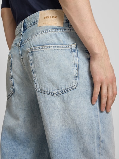 Männermodel trägt Loose Fit Baggy Jeans aus reiner Baumwolle Modell 'FADE' von Only & Sons, hellblauer Denim, Detailaufnahme Rückansicht.