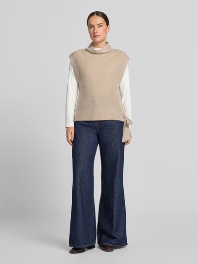 Kobieta nosi Relaxed Fit Pullunder aus reinem Kaschmir mit Stehkragen od Christian Berg Woman, beżowy, ozdobna kokarda, stójka, bez rękawów, długość tyłu w rozmiarze S: 52 cm, pełen widok z przodu.