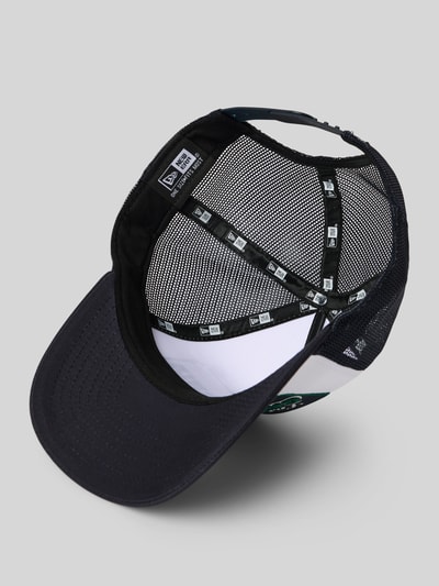 Produktfoto, 'Trucker Cap mit Location Patch' von New Era z bawełny, siateczka, regulowane zapięcie, czarny przód i boki, detal wnętrza czapki