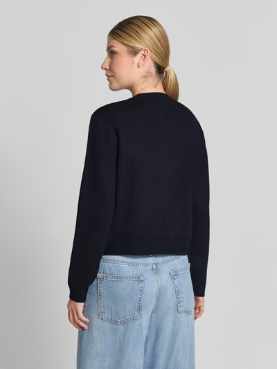 Frauenmodel trägt Cardigan aus Viskose-Mix mit Zierknöpfen Modell 'GENIO' von MANGO in Dunkelblau, Rückenansicht, Ganzkörperansicht Rückansicht.
