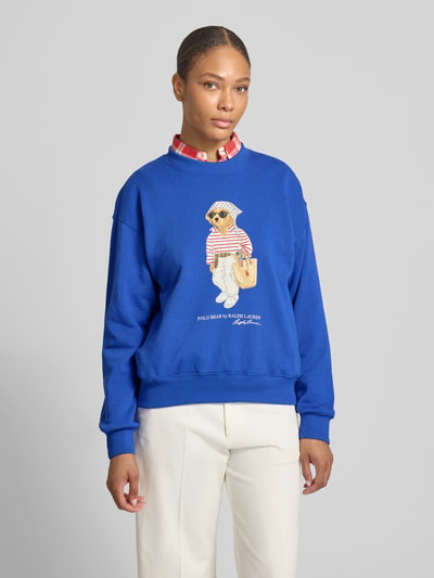 Frauenmodel trägt Regular Fit Sweatshirt aus Baumwoll-Mix mit Bear-Motiv von Polo Ralph Lauren in Blau, unifarben, Motiv-Print, Rundhals, langarm, Ganzkörperansicht von vorne.