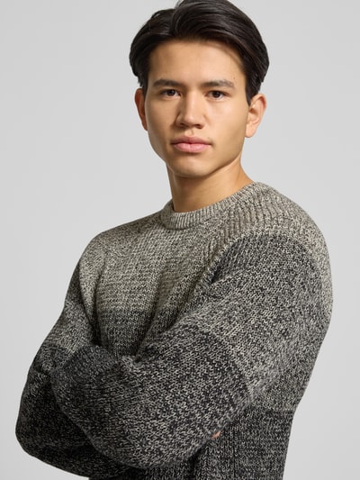 Männermodel trägt Relaxed Fit Strickpullover aus reiner Baumwolle Modell 'BIRK' von Only & Sons, Melange-Optik, Ombré-Muster, Nahaufnahme Oberkörper.