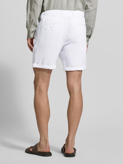 Männermodel trägt Leinenshorts mit Bindegürtel und Gesäßtaschen von MCNEAL, biały len, krój straight fit, zakładka, wyhaftowane logo, Ganzkörperansicht Rückansicht.