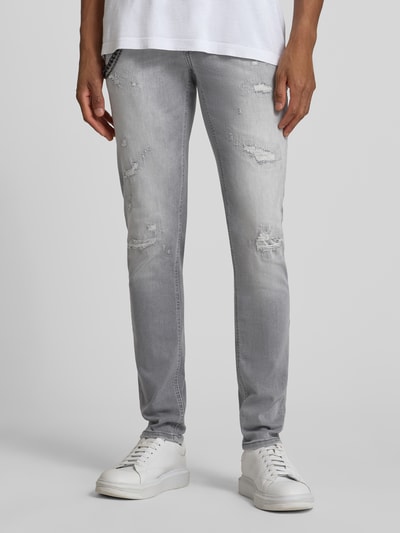 Männermodel trägt Tapered Fit Jeans mit Ketten-Detail von Antony Morato, grauer Baumwoll-Elasthan-Mix im Destroyed-Look, 5-Pocket-Design, Ganzkörperansicht von vorne.