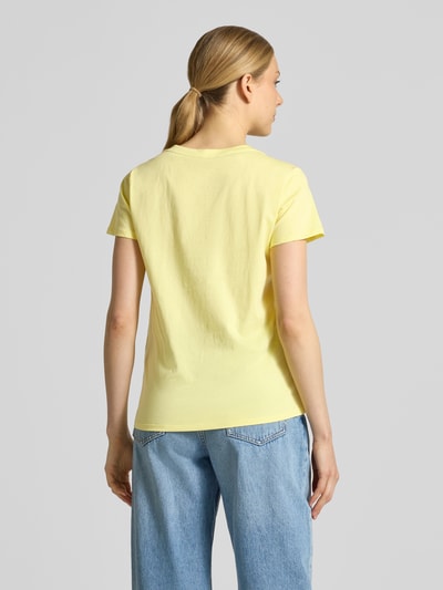 Modelka kobieca nosi T-Shirt mit Rundhalsausschnitt und Strasssteinbesatz od LIU JO SPORT, żółty kolor, bawełna, prosty krój, widok całej sylwetki z tyłu, długość pleców w rozmiarze S: 60 cm.