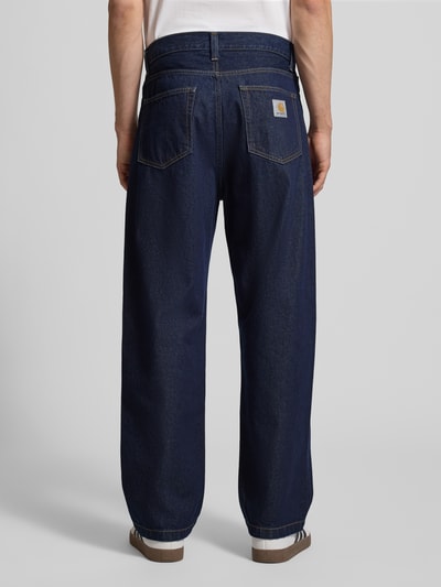 Mężczyzna-model nosi Jeansy z wpuszczanymi kieszeniami Model 'Landon Pant Robertson' od Carhartt Work In Progress z bawełny, krój relaxed fit, szerokość w rozmiarze 32: 44 cm, długość wewnętrzna nogawki w rozmiarze 32: 78 cm, widok całej sylwetki z tyłu.