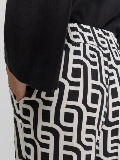 Vrouwenmodel draagt Wide Leg Pants uit viscose met steekzakken van Christian Berg Woman, zwart-wit grafisch patroon, detailopname heup.