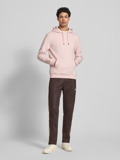 Männermodel trägt Regular Fit Hoodie aus Baumwoll-Mix Modell 'CERES' von Only & Sons in Rosa, unifarben, Sweat-Optik, Ganzkörperansicht von vorne.