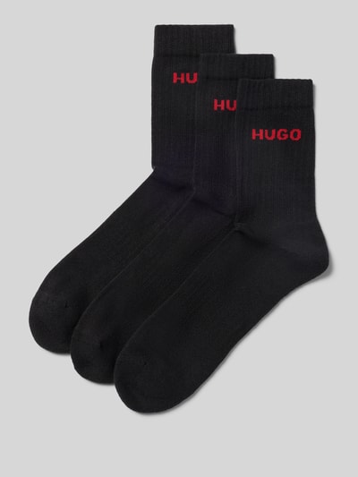 Produktfoto, zwarte geribbelde sokken van katoenmix, rood HUGO-logo, effen design, zachte textuur, set van drie paar