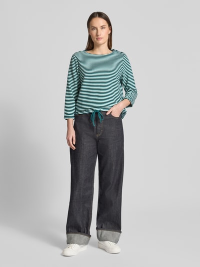 Vrouwenmodel draagt Regular Fit 3/4-Shirt aus Bio-Baumwoll-Mix van Tom Tailor met allover gestreept motief, knopen aan ronde hals, tunnelkoordzoom, ribstructuur, driekwartmouw, biologisch katoenmix. Volledige lichaamsvoorzijde.