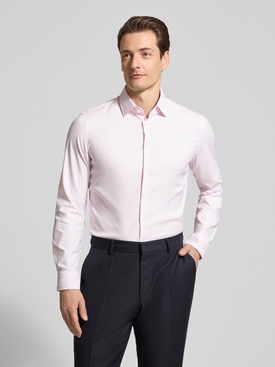 Männermodel trägt Slim Fit Business-Hemd mit Kentkragen von Jake*s, mieszanka materiałów z dodatkiem streczu, krój slim fit, kołnierzyk typu kent, listwa guzikowa, długość tyłu w rozmiarze 39/40: 71 cm, szerokość ramion w rozmiarze 39/40: 45 cm, długość rękawów w rozmiarze 39/40: 65 cm, jasnoróżowy kolor, gładka faktura, całkowity widok z przodu