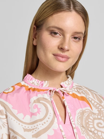 Modelka nosi Regular Fit Bluse mit Allover-Paisley-Print od Emily Van den Bergh, różowy, kremowy, pomarańczowy, czysta bawełna, stójka z falbanką, długie rękawy, rozcięcie na dekolcie, wykończone mankiety, długość pleców w rozmiarze 36: 52 cm, długość rękawa: 60 cm, krój regular fit, detaliczny nadruk paisley, zbliżenie na górną część ciała, widok z przodu.